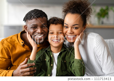 Cheerful black family with son sharing loving moment 111713413