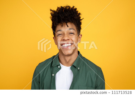 Portrait of laughing african american guy on yellow background Portrait of laughing african american guy on yellow background 111713528