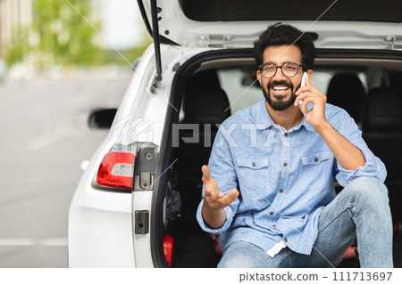 Positive millennial hindu man driver have break, talking on phone Positive millennial hindu man driver have break, talking on phone 111713697