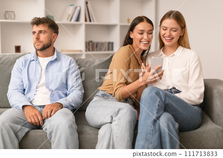 Woman Talking To Female Friend Using Smartphone Ignoring Husband Indoors 111713833