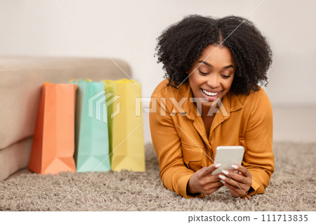 Enthusiastic African American woman in a stylish mustard top smiles Enthusiastic African American woman in a stylish mustard top smiles 111713835