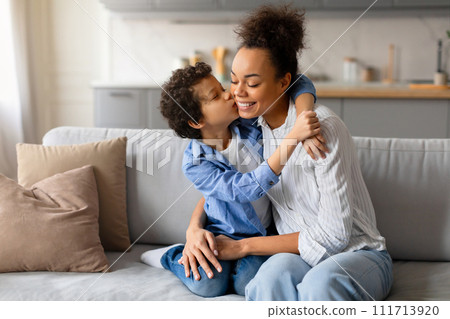 Preteen boy gives loving kiss on the cheek to his joyful mother Preteen boy gives loving kiss on the cheek to his joyful mother 111713920