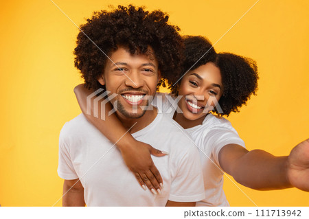 Portrait of beautiful happy african american couple taking selfie 111713942