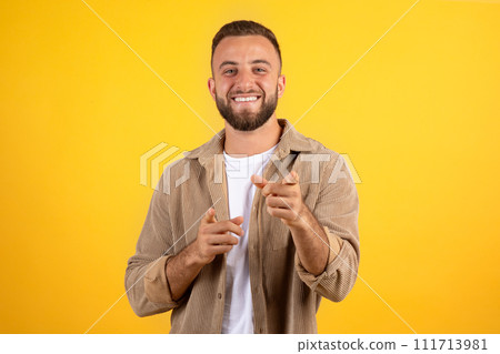 Glad young caucasian guy with beard in casual point fingers at camera, recommendation motivation gesture Glad young caucasian guy with beard in casual point fingers at camera, recommendation motivation gesture 111713981