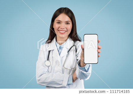 Smiling woman doctor presenting smartphone with blank screen Smiling woman doctor presenting smartphone with blank screen 111714185