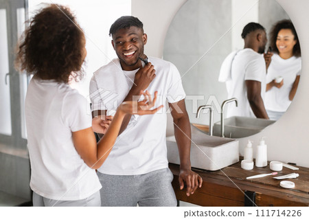 black couple talking and laughing while husband shaving in bathroom black couple talking and laughing while husband shaving in bathroom 111714226