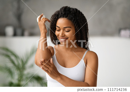 Body Care Concept. Smiling Black Female Rubbing Moisturising Cream On Elbow Body Care Concept. Smiling Black Female Rubbing Moisturising Cream On Elbow 111714236