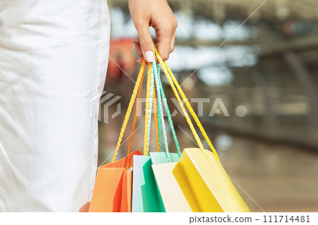 Millennial caucasian woman with many shopping bags in hand, enjoy walk, shopping, close up 111714481