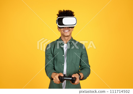Black guy using VR glasses and joystick on yellow background Black guy using VR glasses and joystick on yellow background 111714502