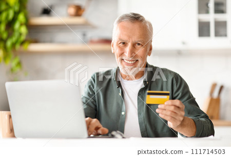 E-Commerce. Smiling Senior Man Holding Credit Card And Using Laptop At Home 111714503