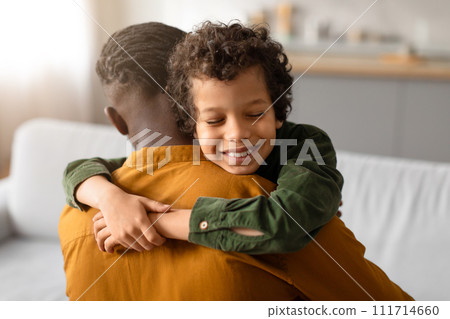 Black boy hugging father with content smile 111714660