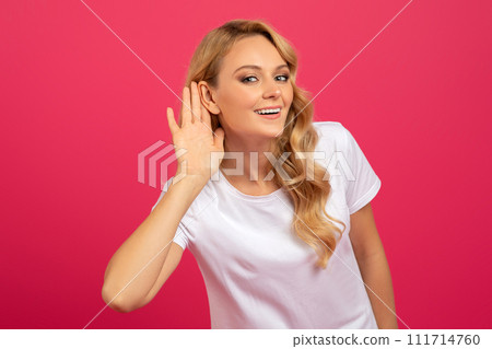 Blonde Woman Listening Holding Hand Near Ear Over Pink Background 111714760