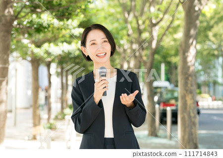 Female announcer with microphone outdoors 111714843