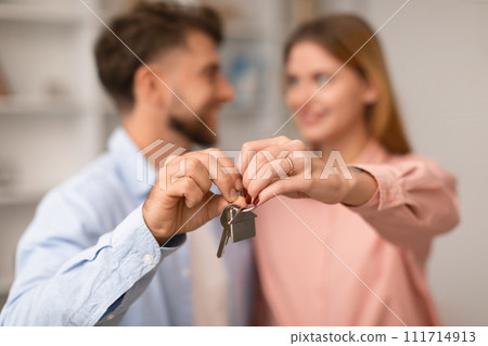 Millennial European couple hugging showing keys to new apartment indoor 111714913