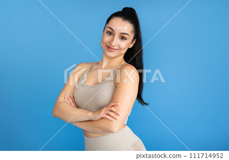 Young woman looking great in her beige exercise outfit, 111714952