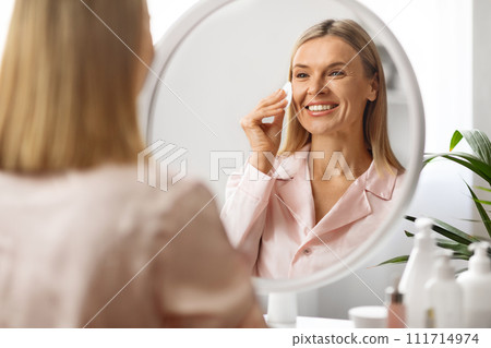Facial Skincare. Middle Aged Woman Using Cotton Pad Cleansing Face At Home Facial Skincare. Middle Aged Woman Using Cotton Pad Cleansing Face At Home 111714974