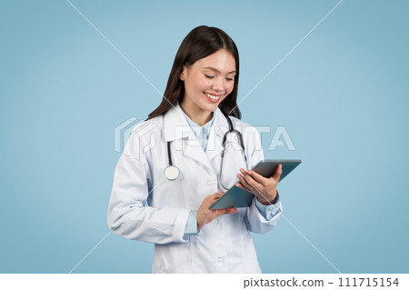 Young female doctor using digital tablet, smiling Young female doctor using digital tablet, smiling 111715154