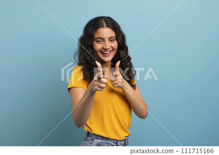 Positive young indian lady pointing at camera and smiling Positive young indian lady pointing at camera and smiling 111715166