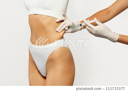 Professional doctor beauty surgeon in gloves make injection in body of young woman 111715377