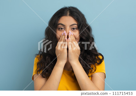 Emotional young indian woman covering her mouth Emotional young indian woman covering her mouth 111715453