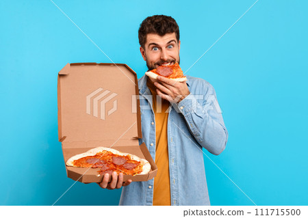 man enjoys slice of pizza holding carton delivery box, studio 111715500