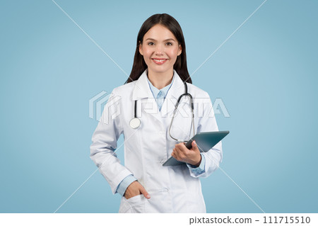 Smiling young female doctor holding tablet and smiling at camera Smiling young female doctor holding tablet and smiling at camera 111715510