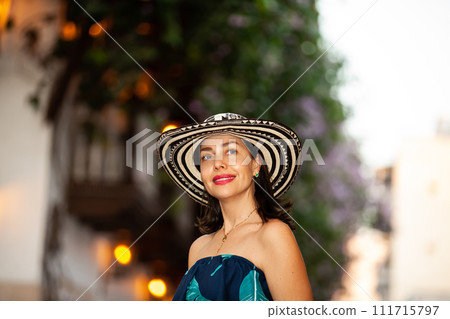 Beautiful woman wearing the traditional Colombian hat called Sombrero Vueltiao at the historical streets of the Cartagena de Indias walled city Beautiful woman wearing the traditional Colombian hat called Sombrero Vueltiao at the historical streets of the Cartagena de Indias walled city 111715797