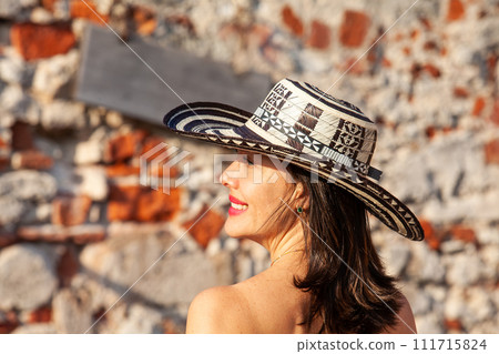 Beautiful woman wearing the traditional Colombian hat called Sombrero Vueltiao at San Ignacio Bulwark in the historical Cartagena de Indias walled city Beautiful woman wearing the traditional Colombian hat called Sombrero Vueltiao at San Ignacio Bulwark in the historical Cartagena de Indias walled city 111715824