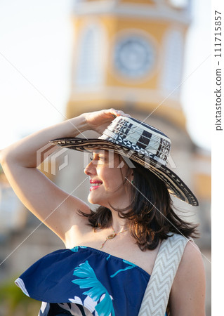 Beautiful woman wearing the traditional Colombian hat called Sombrero Vueltiao at the Clock Tower on the historical streets of the Cartagena de Indias walled city Beautiful woman wearing the traditional Colombian hat called Sombrero Vueltiao at the Clock Tower on the historical streets of the Cartagena de Indias walled city 111715857