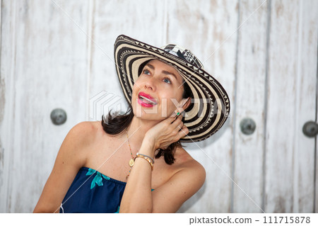 Beautiful woman wearing the traditional Colombian hat called Sombrero Vueltiao at the historical streets of the Cartagena de Indias walled city 111715878