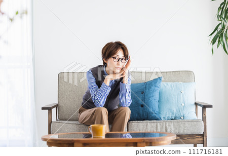 middle-aged woman sitting on the sofa middle-aged woman sitting on the sofa 111716181