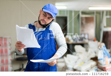 Foreman talking on phone at renovating object 111716259