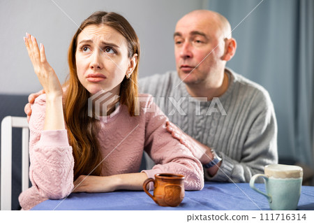 Man tries to comfort his upset wife 111716314