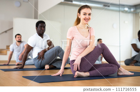 People exercising lord of the fishes asana in gym 111716555