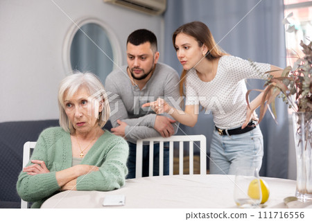 Chagrined senior woman having problems in relationship with couple 111716556
