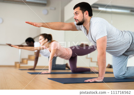 Bearded man standing in balancing asana Dandayamna Bharmanasana 111716562