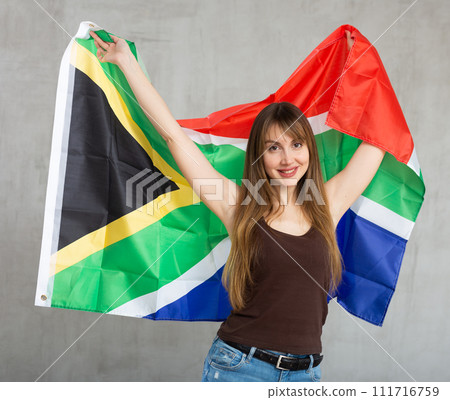 Young cheerful woman holding South African Republic flag Young cheerful woman holding South African Republic flag 111716759