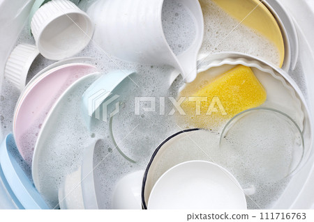 Dishes and bowls in water and bubbles of dishwashing liquid. Kitchen work Dishes and bowls in water and bubbles of dishwashing liquid. Kitchen work 111716763