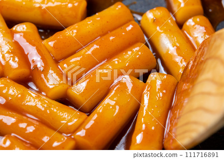 在煎鍋裡製作甜辣辣的炒年糕的烹飪場景。 111716891