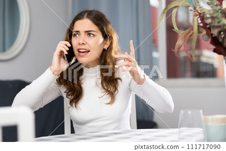 Stressed young woman using phone at home Stressed young woman using phone at home 111717090