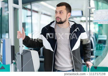 Portrait of male passenger in tram car on spring day 111717139