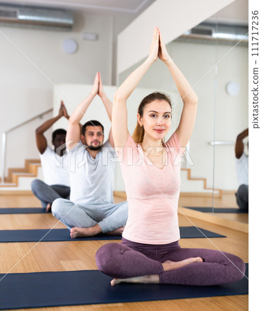 Woman sitting in lotus pose, group training 111717236