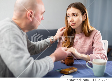 Man comforting his depressed wife at home Man comforting his depressed wife at home 111717238
