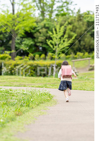 Elementary school girl running to school 111717491