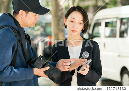 Reporter and cameraman reporting outdoors Reporter and cameraman reporting outdoors 111718180
