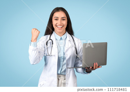 Happy young woman doctor with computer, success gesture 111718481