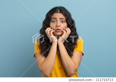 Appalled young indian woman touching her face Appalled young indian woman touching her face 111718713
