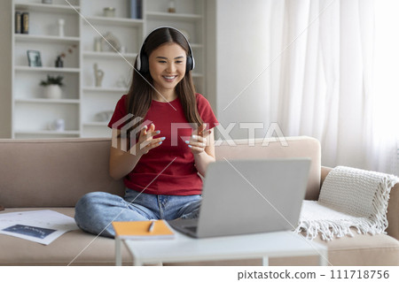 Video Call. Smiling Asian Woman In Headphones Teleconferencing On Laptop At Home 111718756