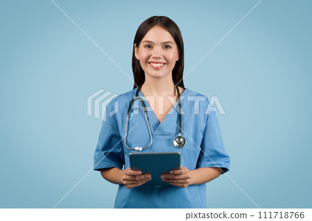 Young female nurse in white coat with tablet smiles Young female nurse in white coat with tablet smiles 111718766