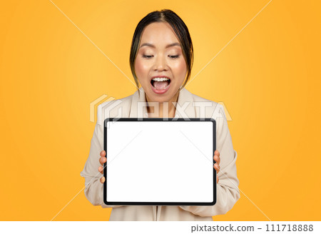 Shocked glad millennial japanese lady in suit, show tablet with empty screen 111718888